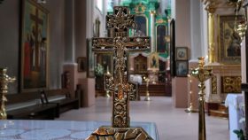 Et fornemt lille ortodoks krucifiks på en bord til lystænding.
